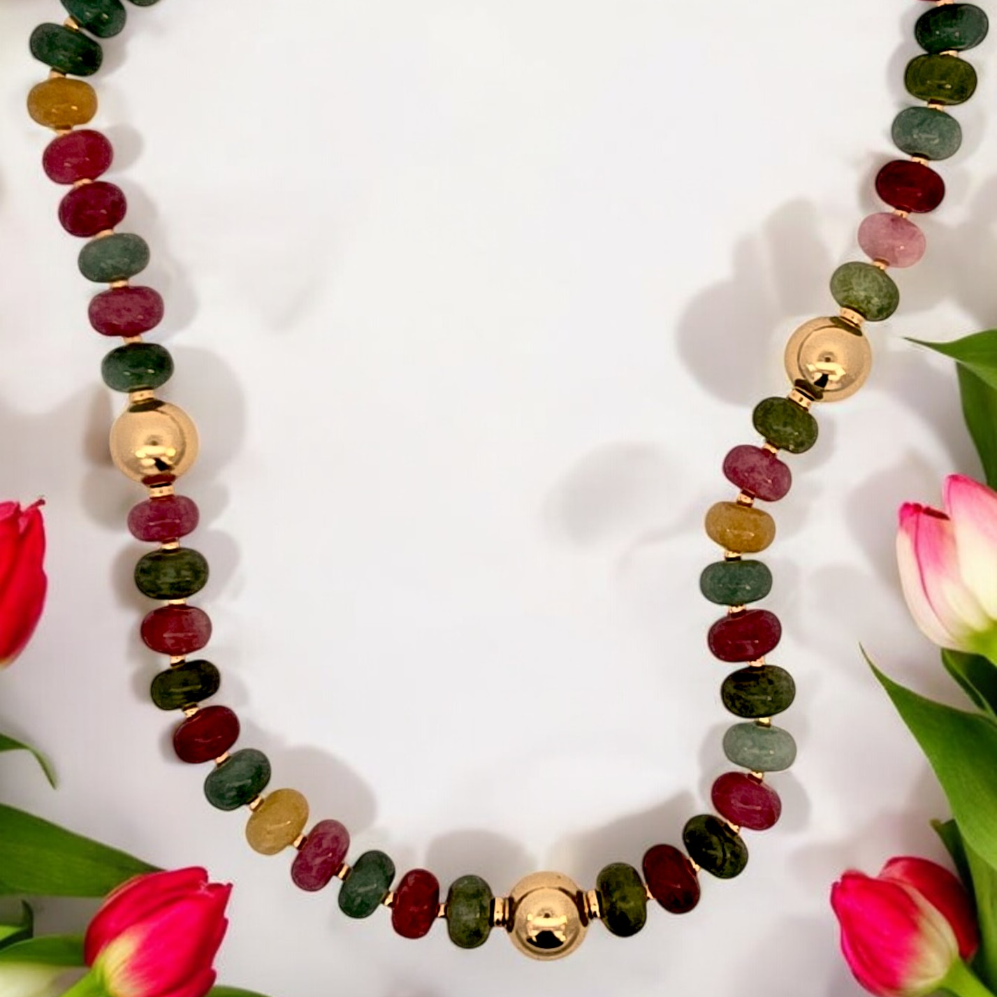 a necklace with various colored stones and flowers