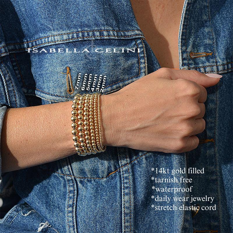 a woman wearing a denim jacket with a stack of bracelets