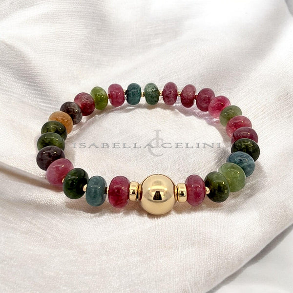 a beaded bracelet with a gold bell charm