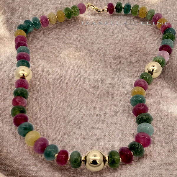 a multicolored beaded necklace on a white cloth