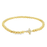 A gold-colored bracelet with small, round beads and a small, clear gemstone or crystal accent piece.