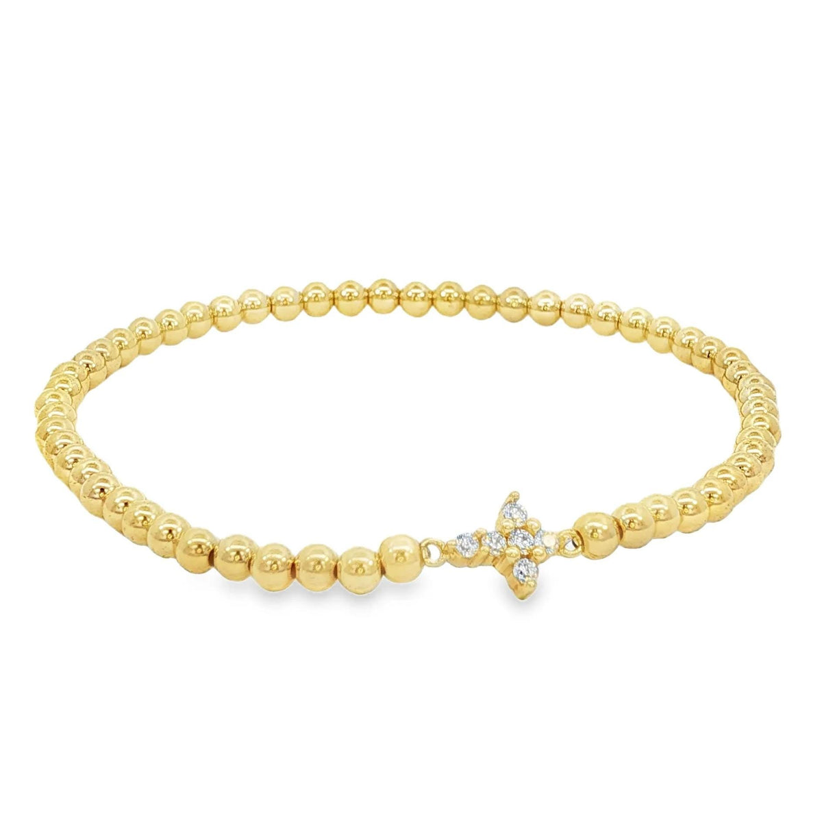 A gold-colored bracelet with small, round beads and a small, clear gemstone or crystal accent piece.