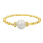 A gold-colored bracelet with a large pearl at the center, surrounded by small gold beads.