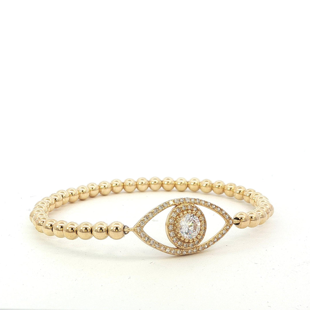A gold-colored bracelet with a large diamond-encrusted eye charm in the center.