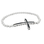 A silver-toned bracelet with a cross-shaped charm featuring black gemstones.