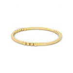 A gold-colored bracelet with a curved design and small, round beads along the edge.