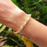 Isabella Celini gold-filled beaded stretch bracelet with a bamboo bar accent worn on a wrist against a green background
